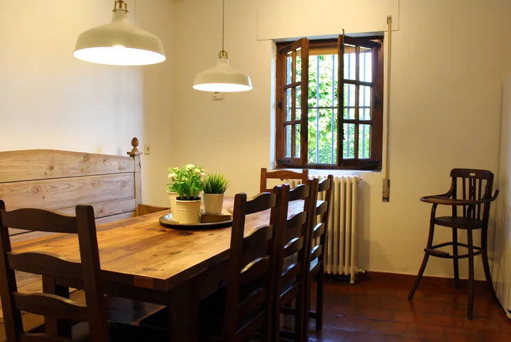 Interior · comedor junto a la cocina, con banco corrido y sillas.